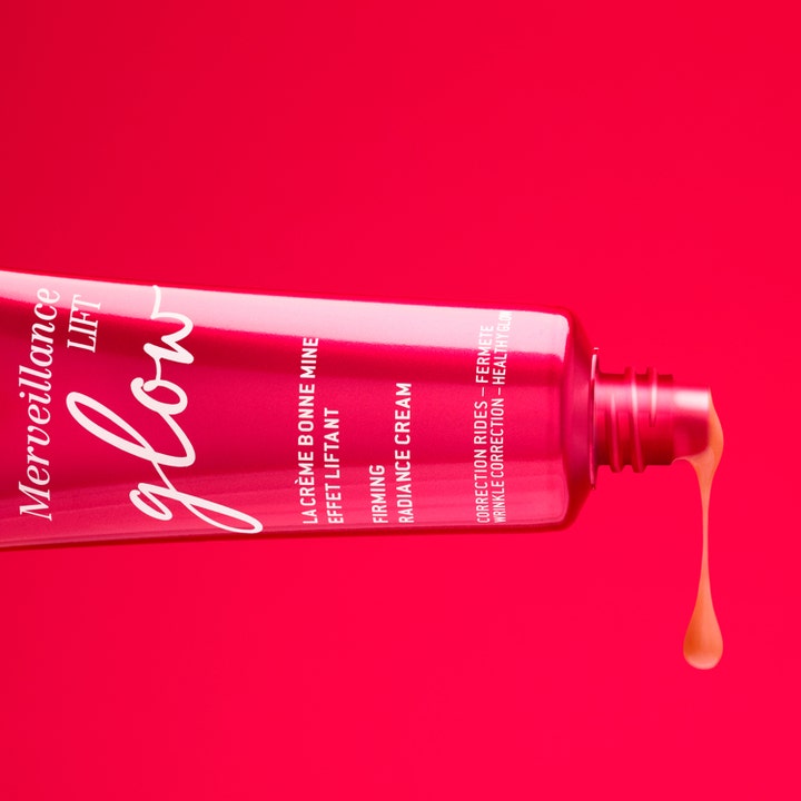 Nuxe Merveillance Lift Glow 50 ml kiinteyttävä päivävoide, jonka persikkainen koostumus valuu punaisesta tuubista.