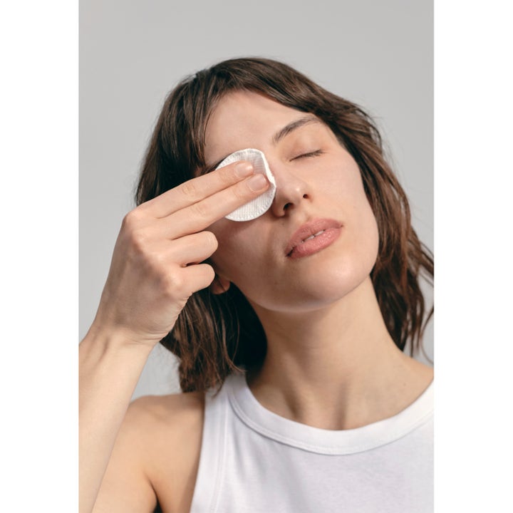 Jorgobé Micellar Cleansing Water 150 ml puhdistava misellivesi, jolla nainen poistaa silmämeikkiä vanulapulla.