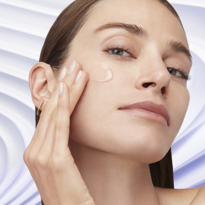 Lancôme Rénergie Discovery Kit niacinamidi ihonhoitosetti jossa malli levittää kirkasta seerumia kasvoille.