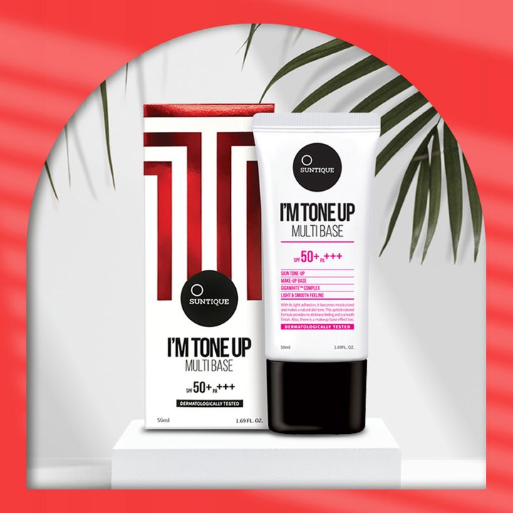 Suntique I'm Tone Up Multi Base 50 ml sävyä tasoittava SPF 50+ aurinkovoide valkoisessa tuubissa palmunlehtien edessä.