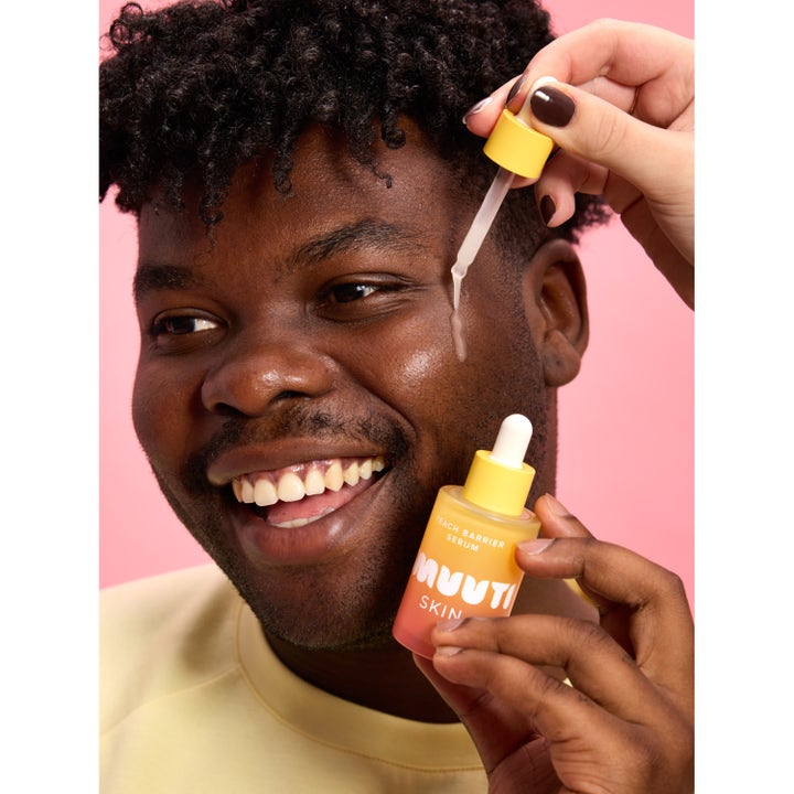 Smuuti Skin Peach Barrier Serum 30 ml kasvoseerumi levitetään pipetillä hymyilevän henkilön kasvoille.