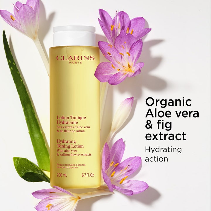 Clarins Hydrating Toning Lotion 400 ml kosteuttava kasvovesi keltaisessa pullossa aloe veran ja kukkien ympäröimänä