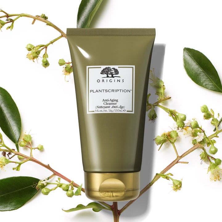 Origins Plantscription Anti-age Cleanser 150 ml puhdistustuote oliivinvihreässä tuubissa kasvien ympäröimänä.