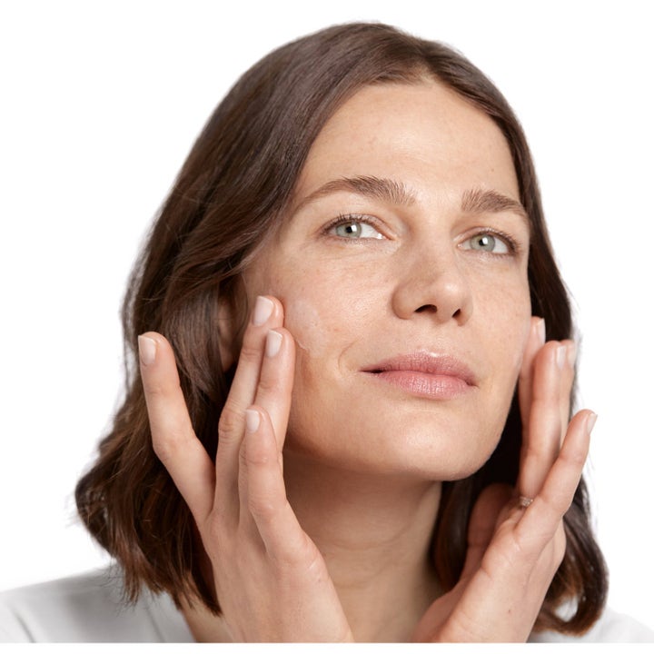 Clinique For Men Anti-Age 65 ml ryppyjä silottava kasvovoide jota nainen levittää sormin poskilleen.