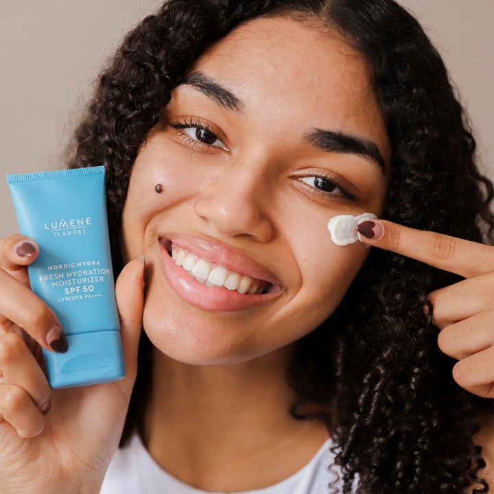 Lumene Nordic Hydra Fresh Hydration Moisturizer SPF50 50 ml päivävoide sinisessä tuubissa nainen levittää voidetta