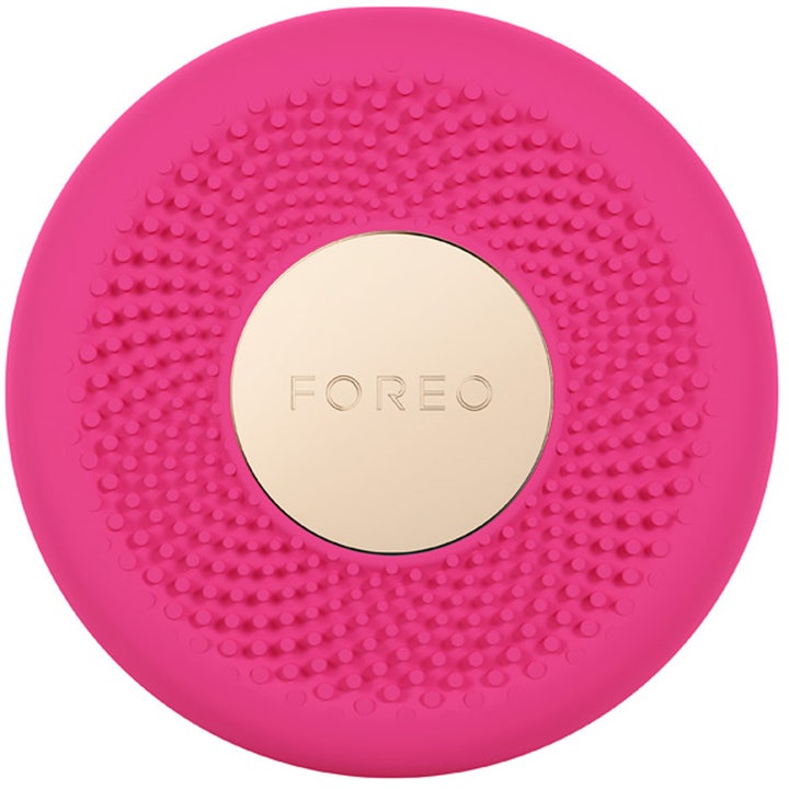 Foreo UFO 1 kpl heleyttävä kasvonaamiolaite on pyöreä pinkki silikonilaite, jonka keskellä on kultainen metallilevy.