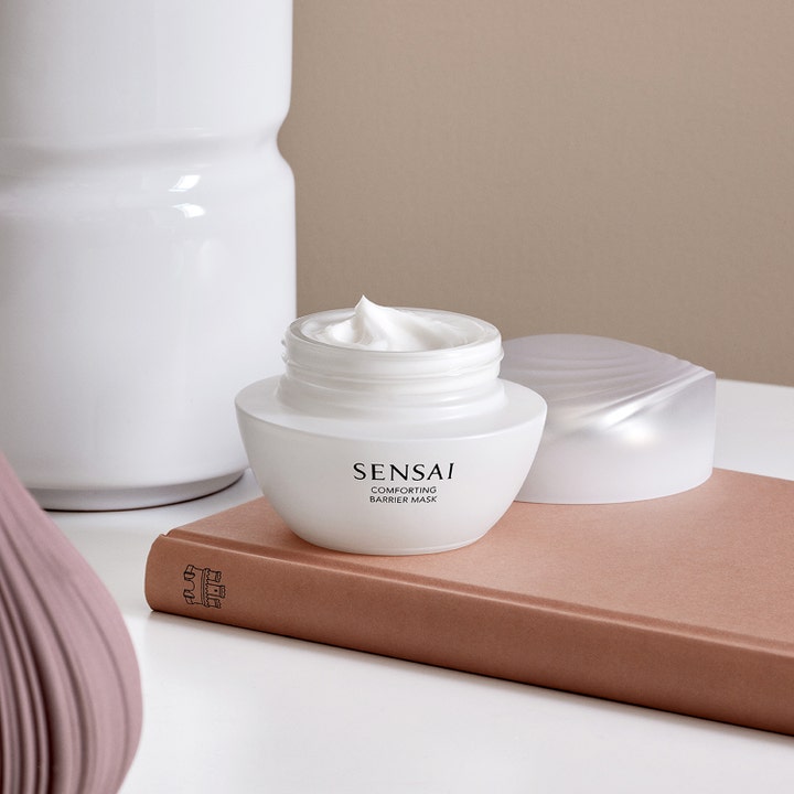Sensai Comforting Barrier Mask 60 ml rauhoittava kasvonaamio avatussa valkoisessa purkissa, jossa näkyy täyteläinen voide.