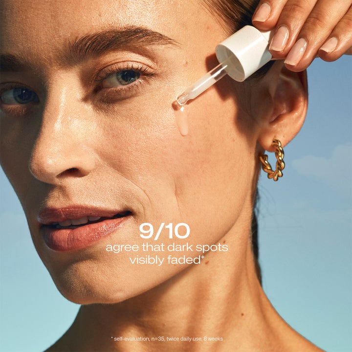 Lumene Dark Spot Serum 30 ml kirkastava seerumi levitettynä pipetillä naisen kasvoille.