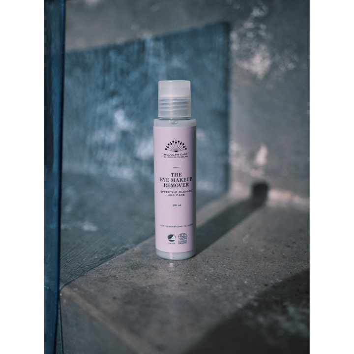 Rudolph Care The Eye Makeup Remover 100 ml puhdistava silmämeikinpoistoaine hennon vaaleanpunaisessa pullossa.