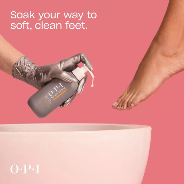 OPI Nature Strong Soften Up Pedi Soak 250 ml pehmentävä jalkakylpy harmaassa pumppupullossa jalan ja pesuvadin kera.