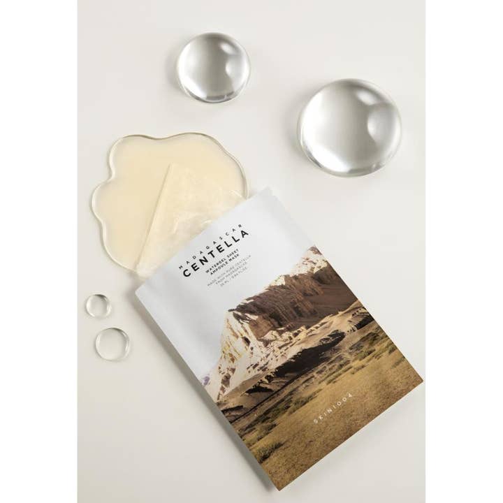 SKIN1004 Madagascar Centella Watergel Sheet Ampoule Mask 25 ml rauhoittava kangasmaski valkoisessa pussissa vesipisaroilla.