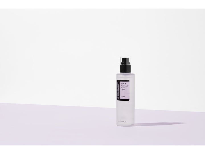 COSRX AHA 7 Whitehead Power Liquid 100 ml kirkastava kuoriva neste läpikuultavassa pullossa liilalla taustalla.