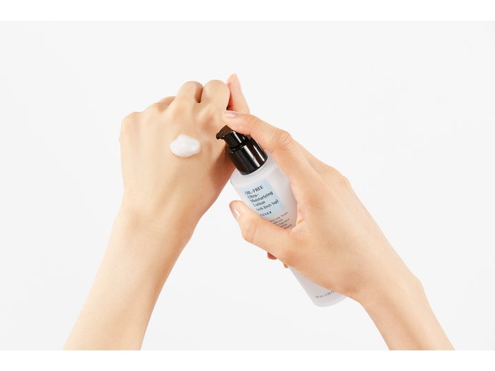 COSRX Oil Free Ultra Moisturizing Lotion 100 ml kasvovoide, kevyt valkoinen koostumus kädellä ja pumppupullo.