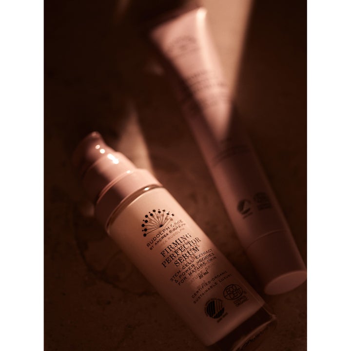 Kiinteyttävä Rudolph Care Firming Perfector Serum 30 ml kasvoseerumi vaaleassa pumppupullossa tunnelmallisessa valossa.