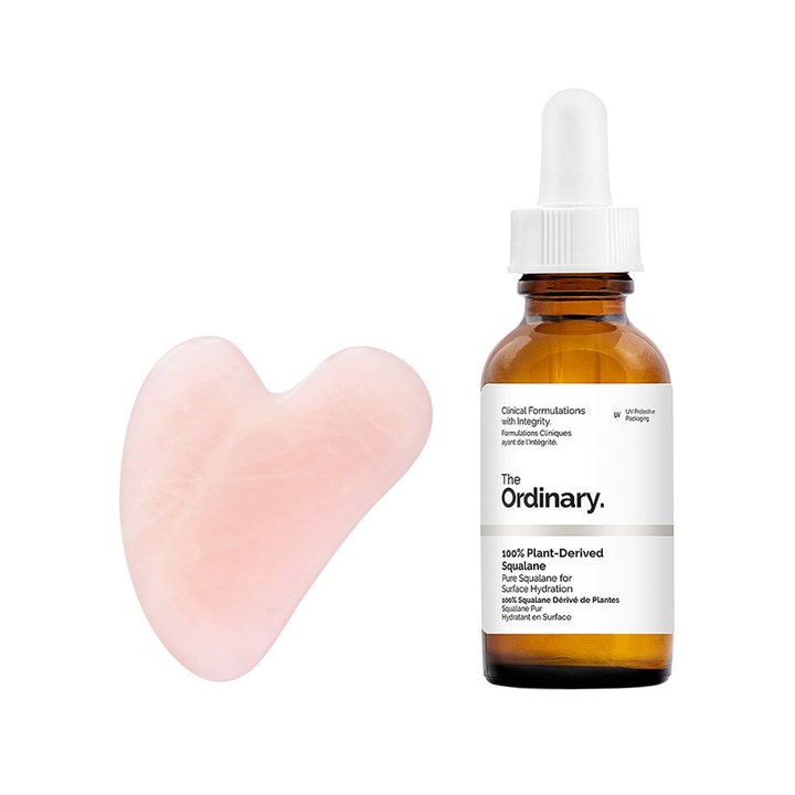 The Ordinary 100% Plant-Derived Squalane 30 ml kosteuttava kasvoöljy ruskeassa lasipullossa ja vaaleanpunainen gua sha -kivi
