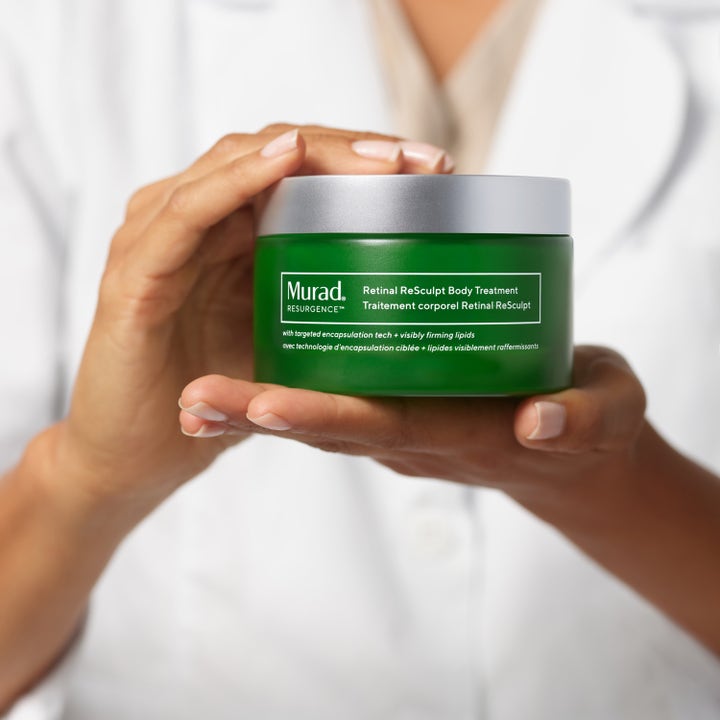 Murad Retinal ReSculpt Body Treatment 148 ml kiinteyttävä vartalovoide vihreässä purkissa ammattilaisen käsissä.