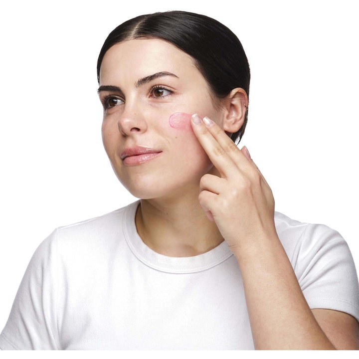 The Ordinary Soothing & Barrier Support Serum 30 ml rauhoittava kasvoseerumi jota nainen levittää vaaleanpunaisena iholle