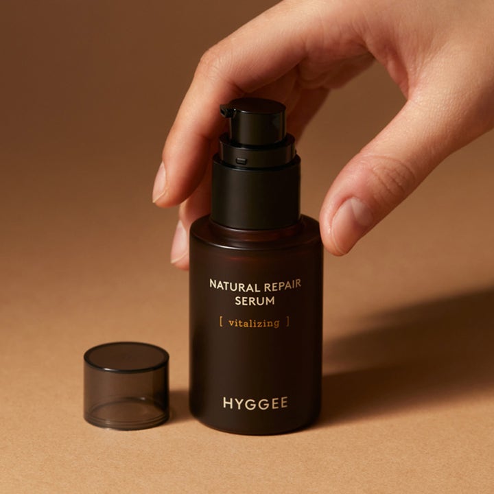 Hyggee Natural Repair Serum 30 ml elvyttävä seerumi tummanruskeassa pumppupullossa käden pitelemänä.