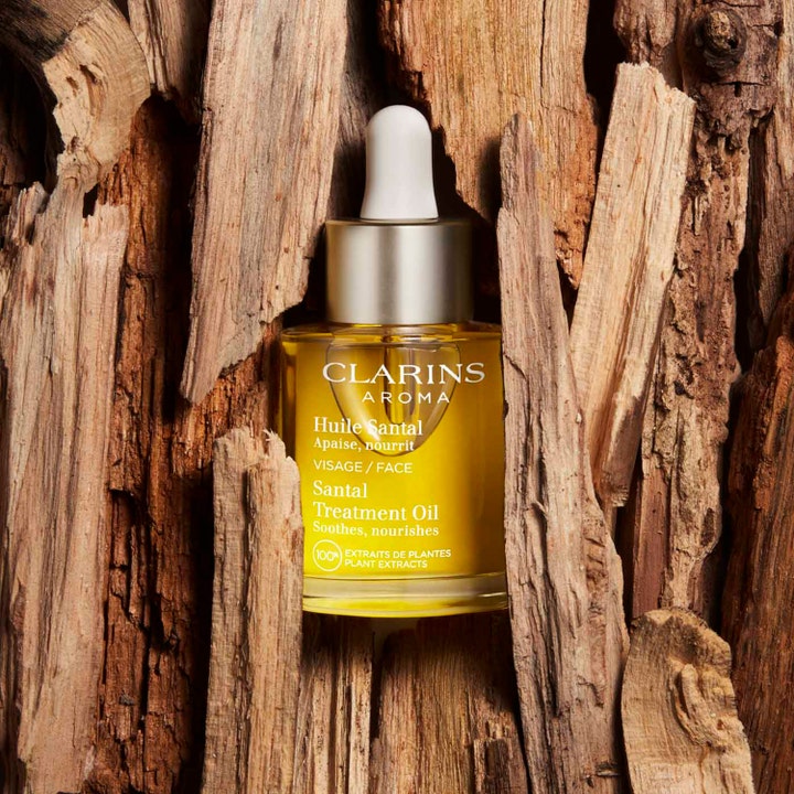 Clarins Santal Face Treatment Oil 30 ml rauhoittava kasvoöljy lasipullossa puun kuorien ympäröimänä