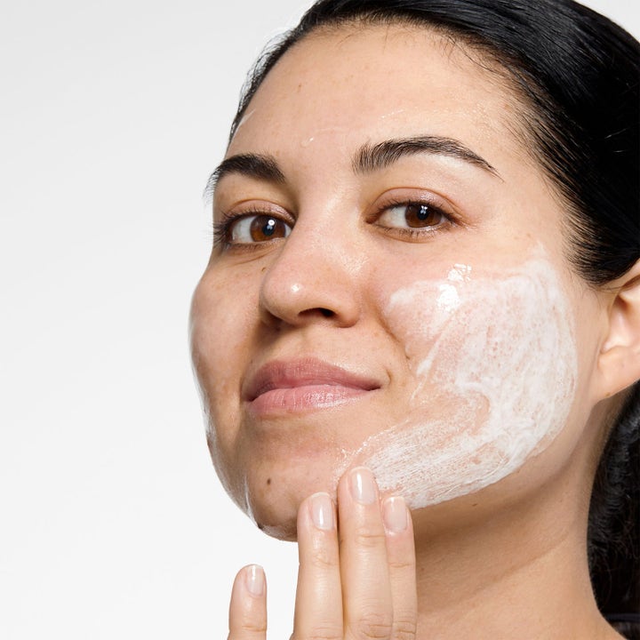 Clinique 3-Step Skincare System 450 ml ihonhoitosetti nainen levittää valkoista puhdistusvoidetta iholle