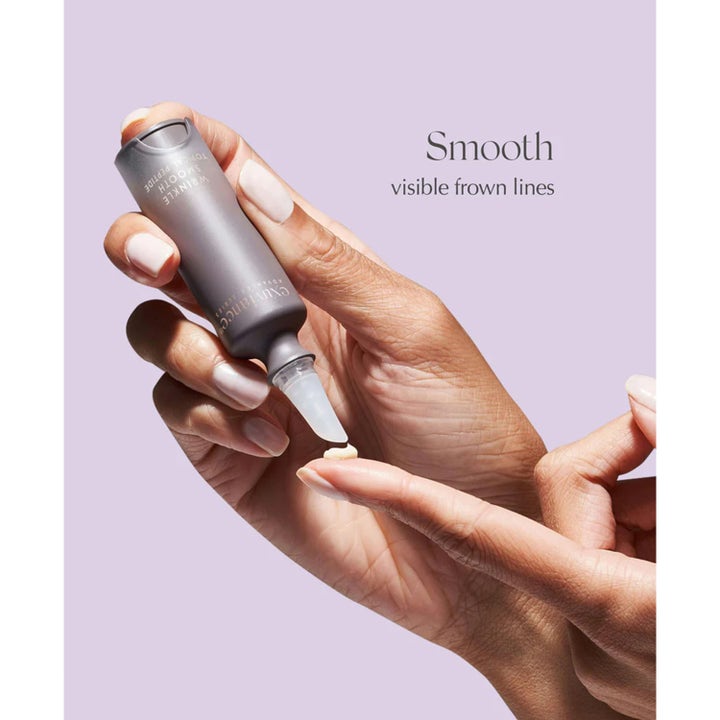 Exuviance Wrinkle Smooth Topical Peptide 5 g silottava seerumi ja vaalea voidekoostumus sormenpäällä.