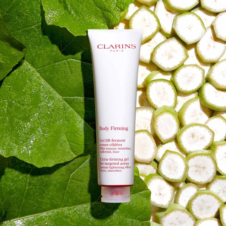Clarins Body Firming 150 ml kiinteyttävä geeli valkoisessa tuubissa vihreiden lehtien ja banaaniviipaleiden keskellä