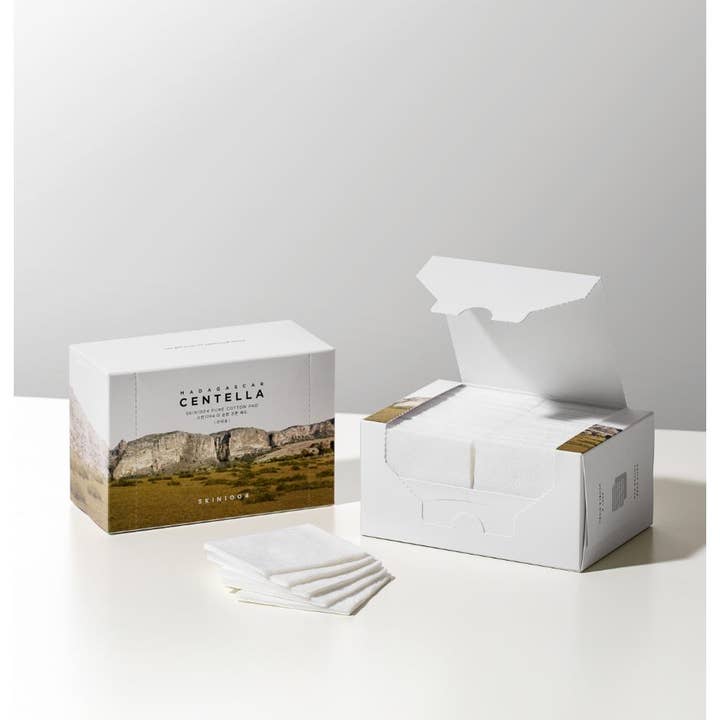 SKIN1004 Madagascar Centella Pure Cotton Pad vanulappuja meikinpoistoon avatussa valkoisessa rasiassa ja pinossa.