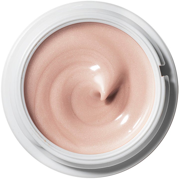 Origins Glow Getter 45 ml heleyttävä silmänympärysvoide, jonka kimmeltävä persikkainen koostumus näkyy avatussa purkissa.