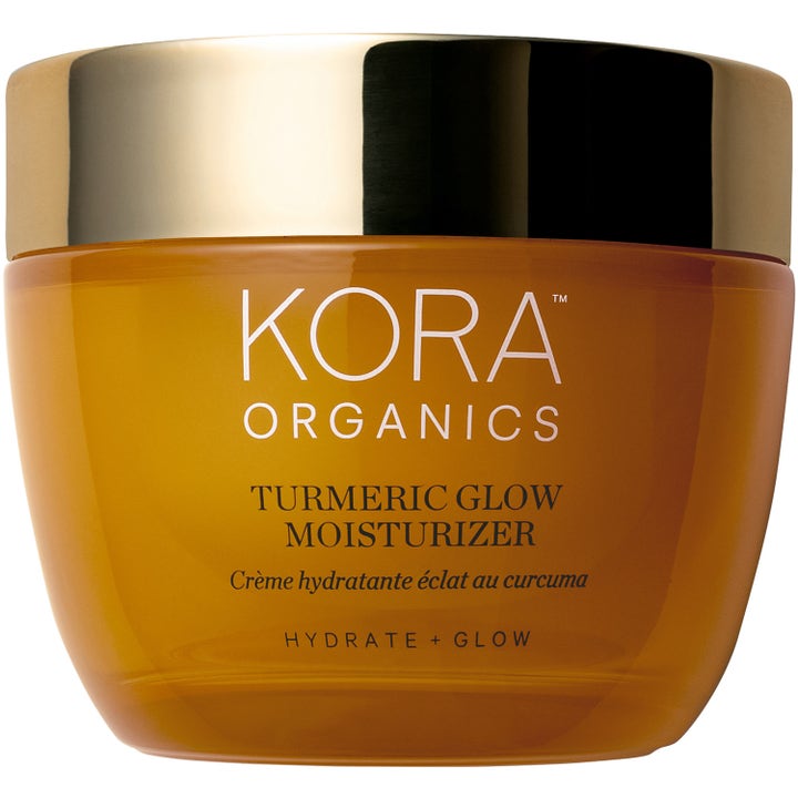 Kora Organics Turmeric Glow Moisturizer hehkua antava kosteusvoide keltaisessa lasipurkissa kultaisella kannella.