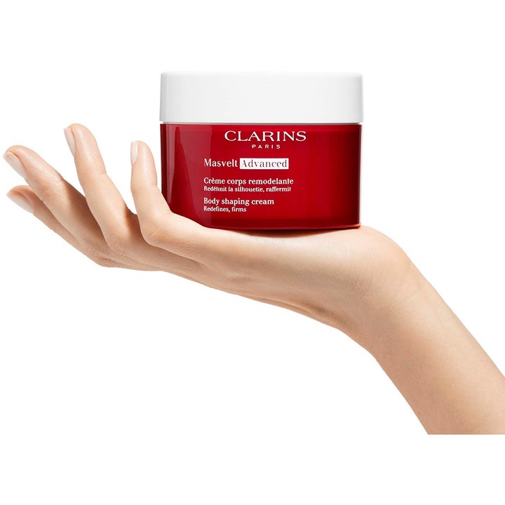 Clarins Masvelt Advanced Body Shaping Cream 200 ml kiinteyttävä vartalovoide punaisessa purkissa kämmenellä.