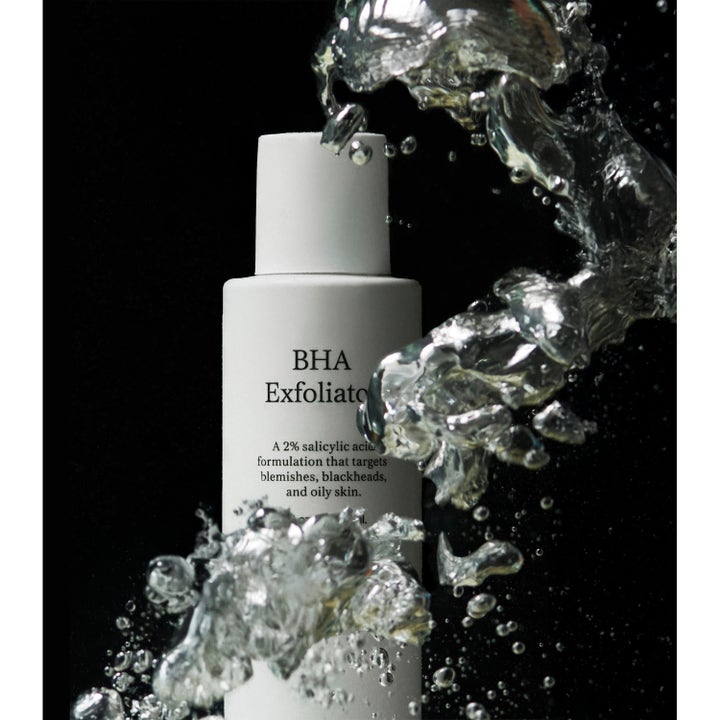 Jorgobé BHA Exfoliator 150 ml kuorinta-aine valkoisessa pullossa dynaamisten vesiroiskeiden ympäröimänä.