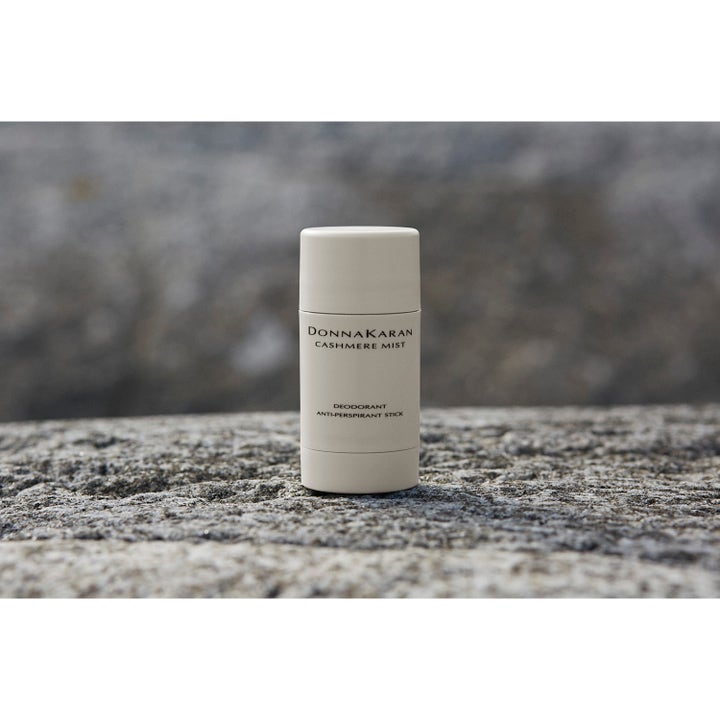DKNY Cashmere Mist Deostick 50 ml raikas antiperspirantti vaaleassa hylsyssä harmaalla kivellä.