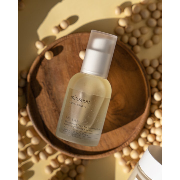 Mixsoon Bean Essence 30 ml kuoriva hoitoneste himmeässä lasipullossa puualustalla soijapapujen ympäröimänä