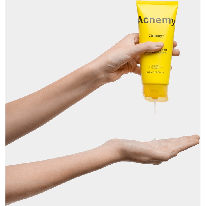 Niche Beauty Lab Acnemy Zitbody 200 ml puhdistava suihkugeeli jota puristetaan keltaisesta tuubista kämmenelle.