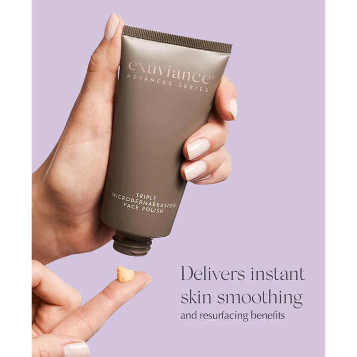 Exuviance Triple Microdermabrasion Face Polish 75 g ihoa silottava kasvokuorinta ruskeassa tuubissa ja voidetta sormella.
