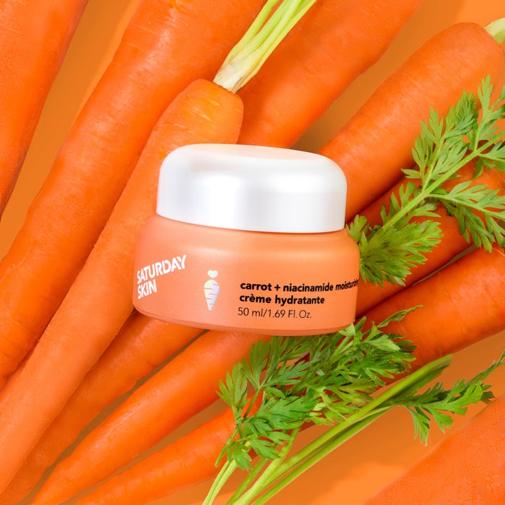 Saturday Skin Carrot + Niacinamide Moisturizing Cream 30 ml kosteusvoide oranssissa purkissa tuoreiden porkkanoiden päällä.