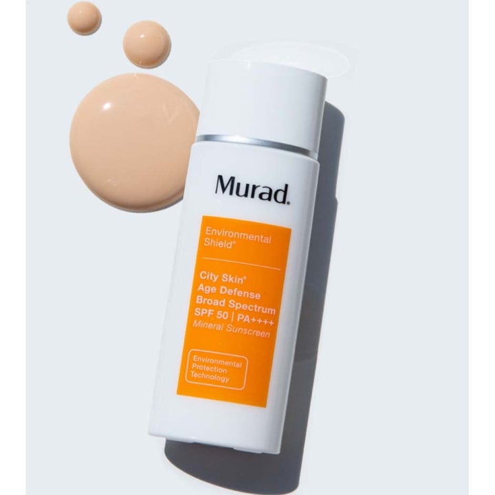 Murad City Skin Age Defense SPF 50 80 ml aurinkovoide valkoisessa pullossa persikanvärisillä voidepisaroilla.