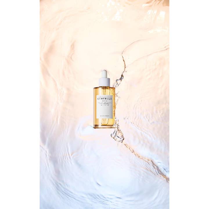 SKIN1004 Madagascar Centella Ampoule 100 ml rauhoittava seerumi lasipullossa veden ja roiskeiden keskellä