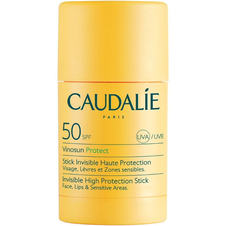 Caudalie Vinosun Protect Stick SPF 50 aurinkosuojapuikko antaa näkymättömän suojan keltaisessa pakkauksessa vihreällä tekstillä.