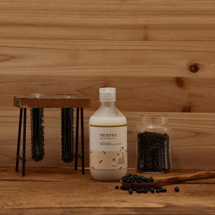 Round Lab Soybean Nourishing Toner 300 ml ravitseva kasvovesi maitomaisessa pullossa mustien papujen ja puun keskellä