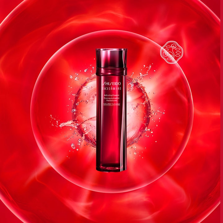 Shiseido Eudermine Activating Essence 150 ml heleyttävä hoitoneste punaisessa kuplassa vesiroiskeiden ympäröimänä