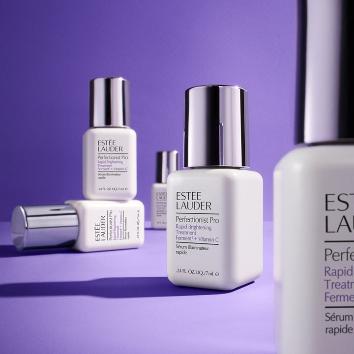 Estée Lauder Perfectionist Pro 30 ml kirkastava C-vitamiiniseerumi valkoisissa pulloissa liilalla taustalla.