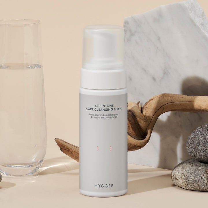 Hyggee All-In-One Care Cleansing Foam 150 ml puhdistusvaahto probiooteilla valkoisessa pumppupullossa luonnon keskellä