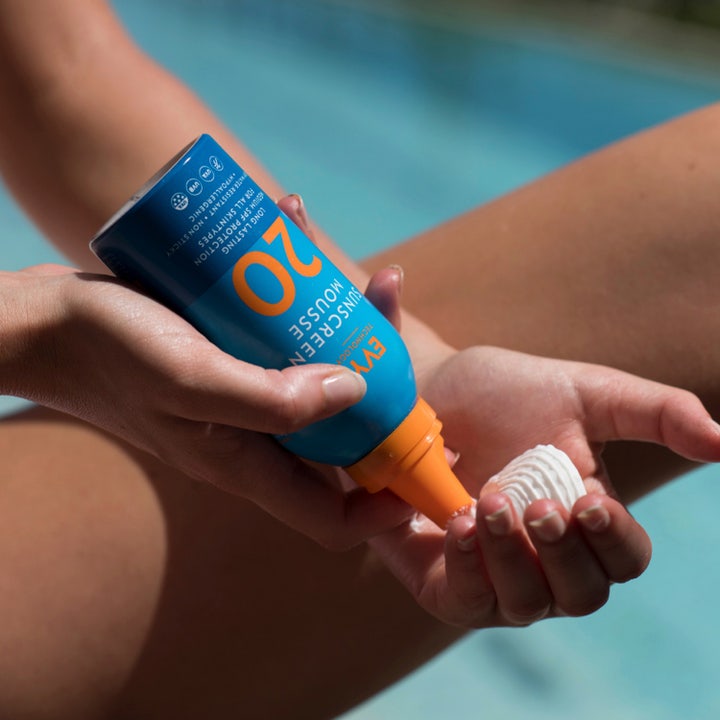 EVY Technology Sunscreen Mousse SPF20 150 ml pitkäkestoinen aurinkosuoja nainen oransseissa bikineissä auringossa