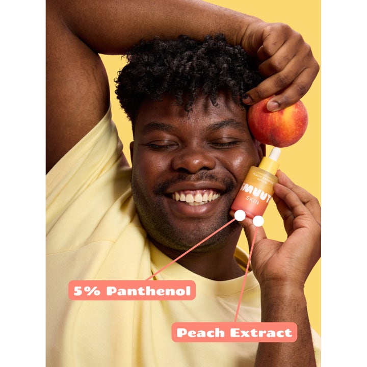 Smuuti Skin Peach Barrier Serum 30 ml rauhoittava seerumi 5 % panthenolia ja persikkauutetta hymyilevän miehen kädessä.