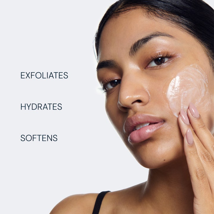 Elemis Pro-Collagen Glow Boost Exfoliator 100 ml kirkastava kasvokuorinta jota nainen levittää poskelleen.