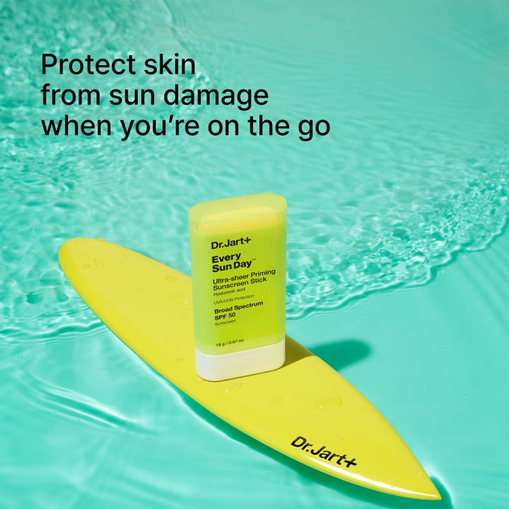 Dr.Jart+ Every Sun Day Ultra-Sheer Priming Sunscreen Stick 19 g suojaa ihoa keltaisella surffilaudalla vedessä.