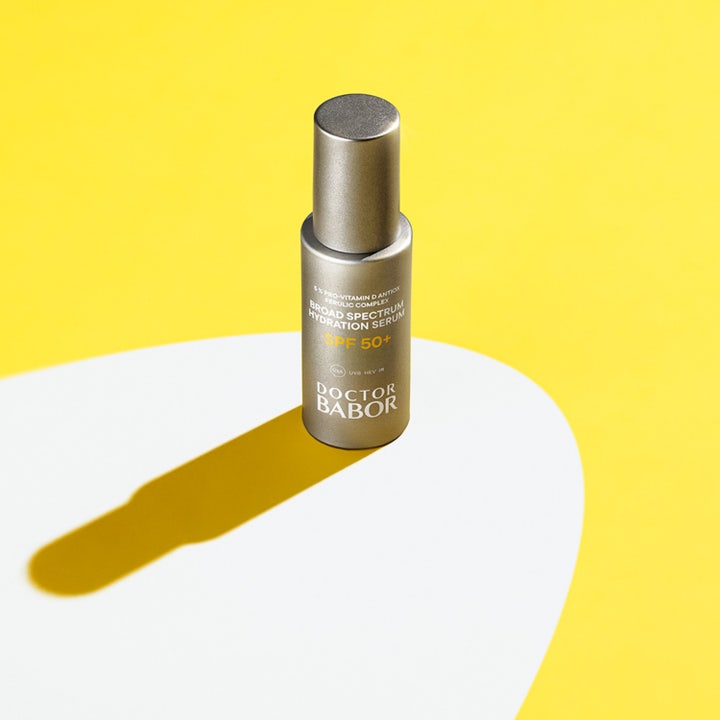 Babor DOC Broad Spectrum Hydration Serum 30 ml kosteuttava seerumi SPF 50+ hopeisessa pullossa keltaisella taustalla.