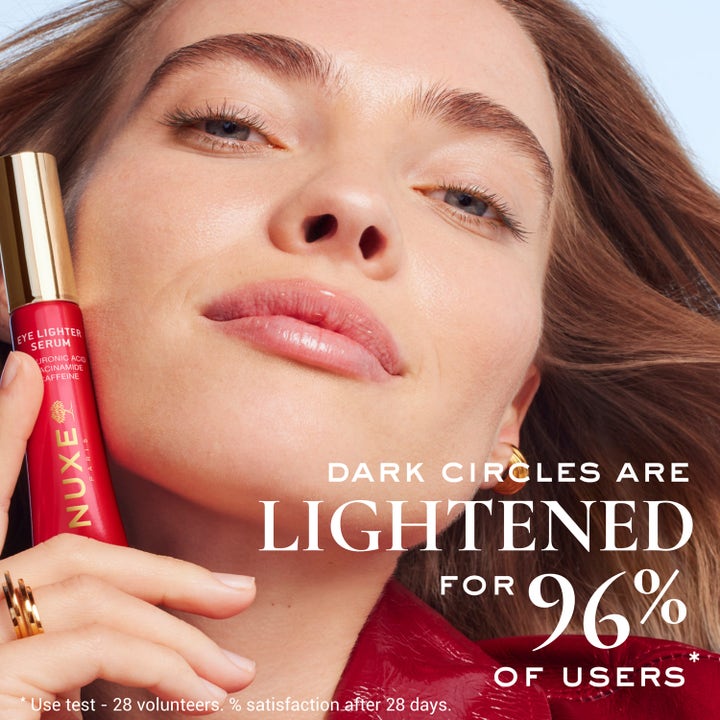 Nuxe Merveillance Lift Eye-Lighter Serum 15 ml kirkastava silmänympärysseerumi punaisessa tuubissa naisen kasvoilla.