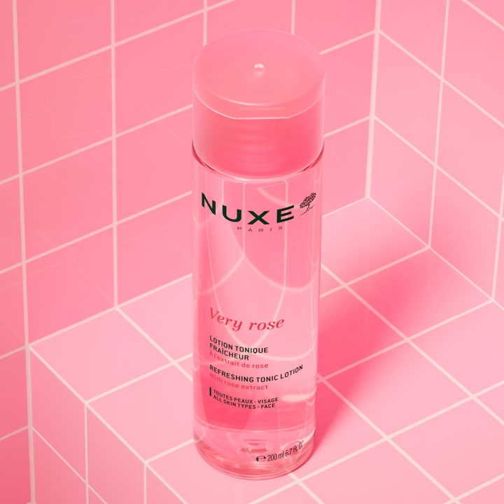 Nuxe Very Rose Refreshing Tonic Lotion 200 ml virkistävä kasvovesi pinkissä pullossa vaaleanpunaista laatastoa vasten.